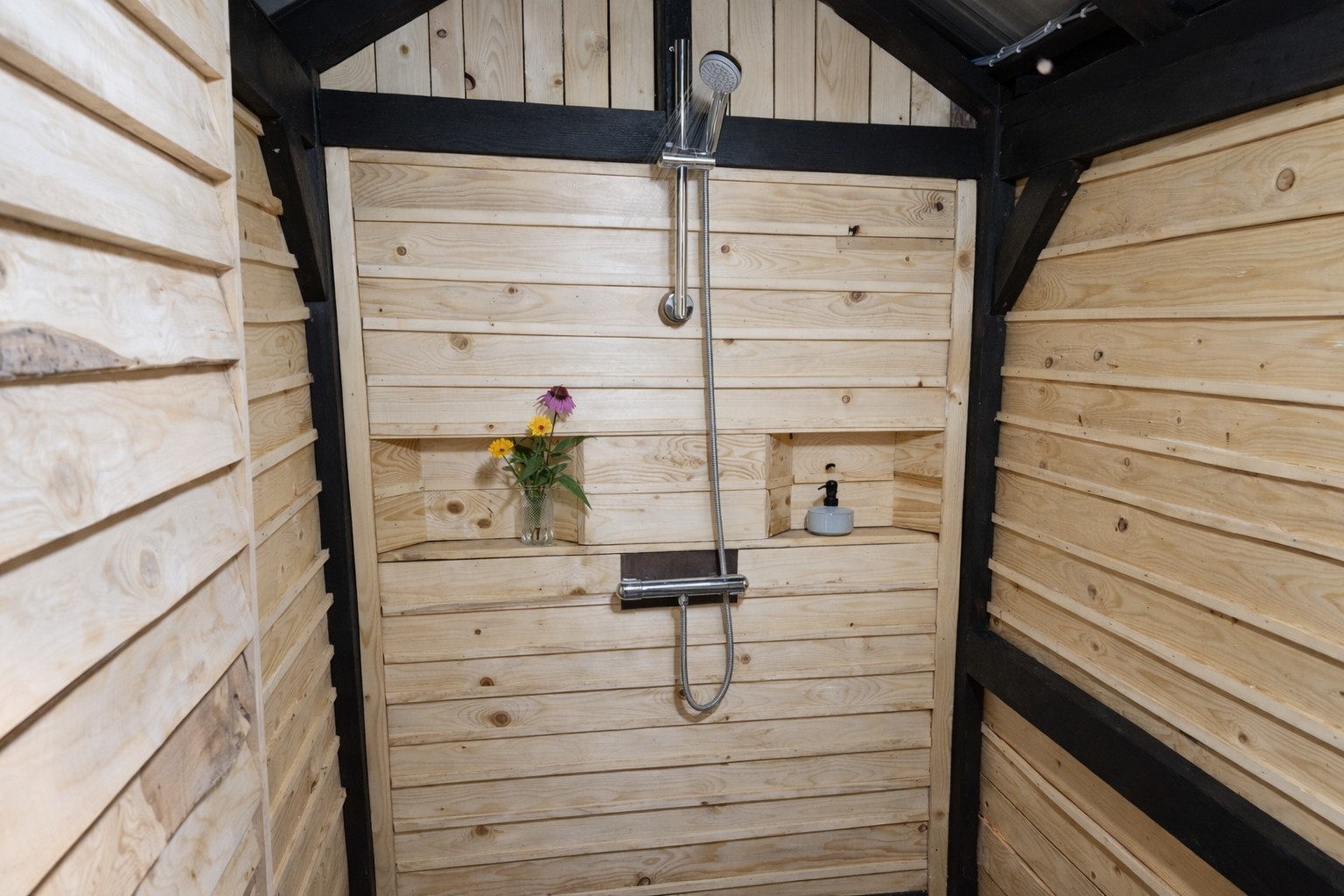 Innenraum der Holzduschkabine mit warmem Wasser bei PasneserPark