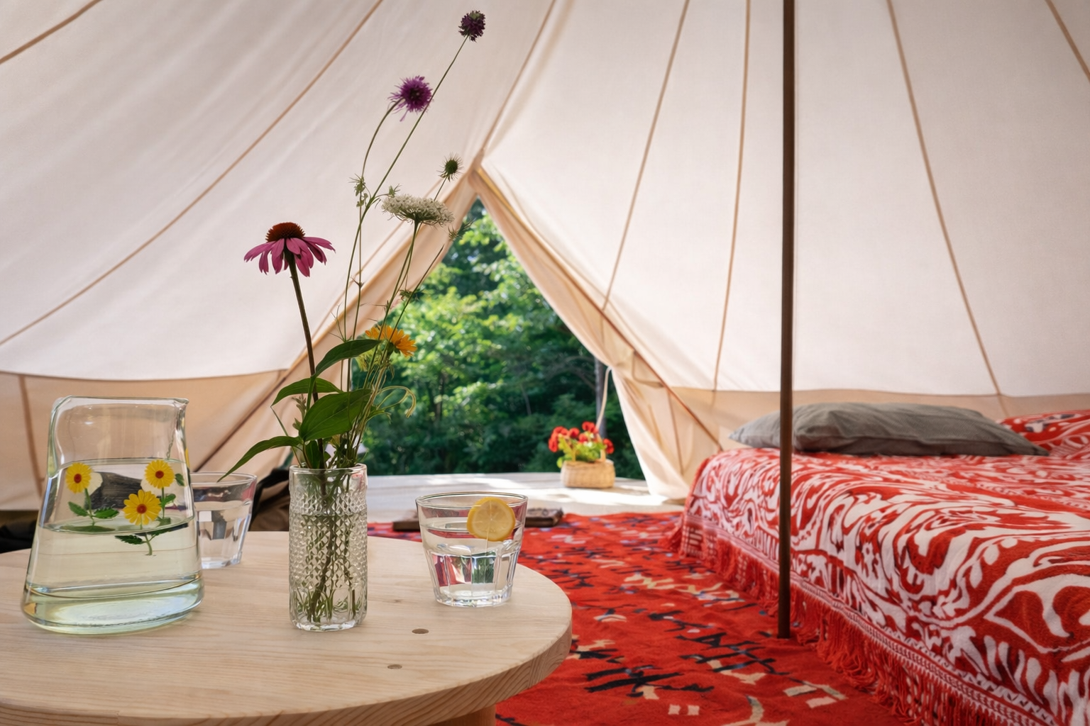 Innenraum des Glamping-Zelts mit bequemem Doppelbett und Ambientebeleuchtung